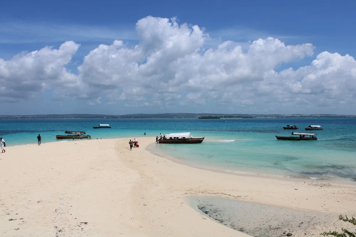 Traditional wooden boats on a sandy beach in Zanzibar, Tanzania.